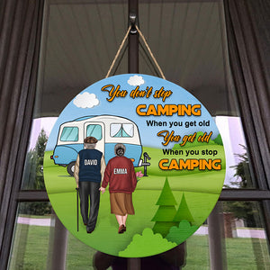 You Get Old When You Stop Camping - Personalized Round Wooden Sign - Gift For Couple - Old Couple Hand In Hand Back View - Wood Sign - GoDuckee