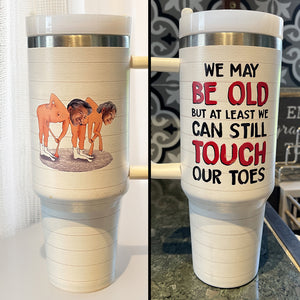 We May Be Old But At Least We Can Still Touch Our Toes, Personalized Tumbler With Handle, Valentine Gifts, Couple Gifts - Tumbler Cup - GoDuckee