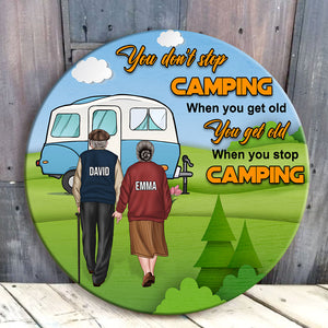 You Get Old When You Stop Camping - Personalized Round Wooden Sign - Gift For Couple - Old Couple Hand In Hand Back View - Wood Sign - GoDuckee