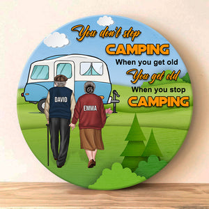 You Get Old When You Stop Camping - Personalized Round Wooden Sign - Gift For Couple - Old Couple Hand In Hand Back View - Wood Sign - GoDuckee